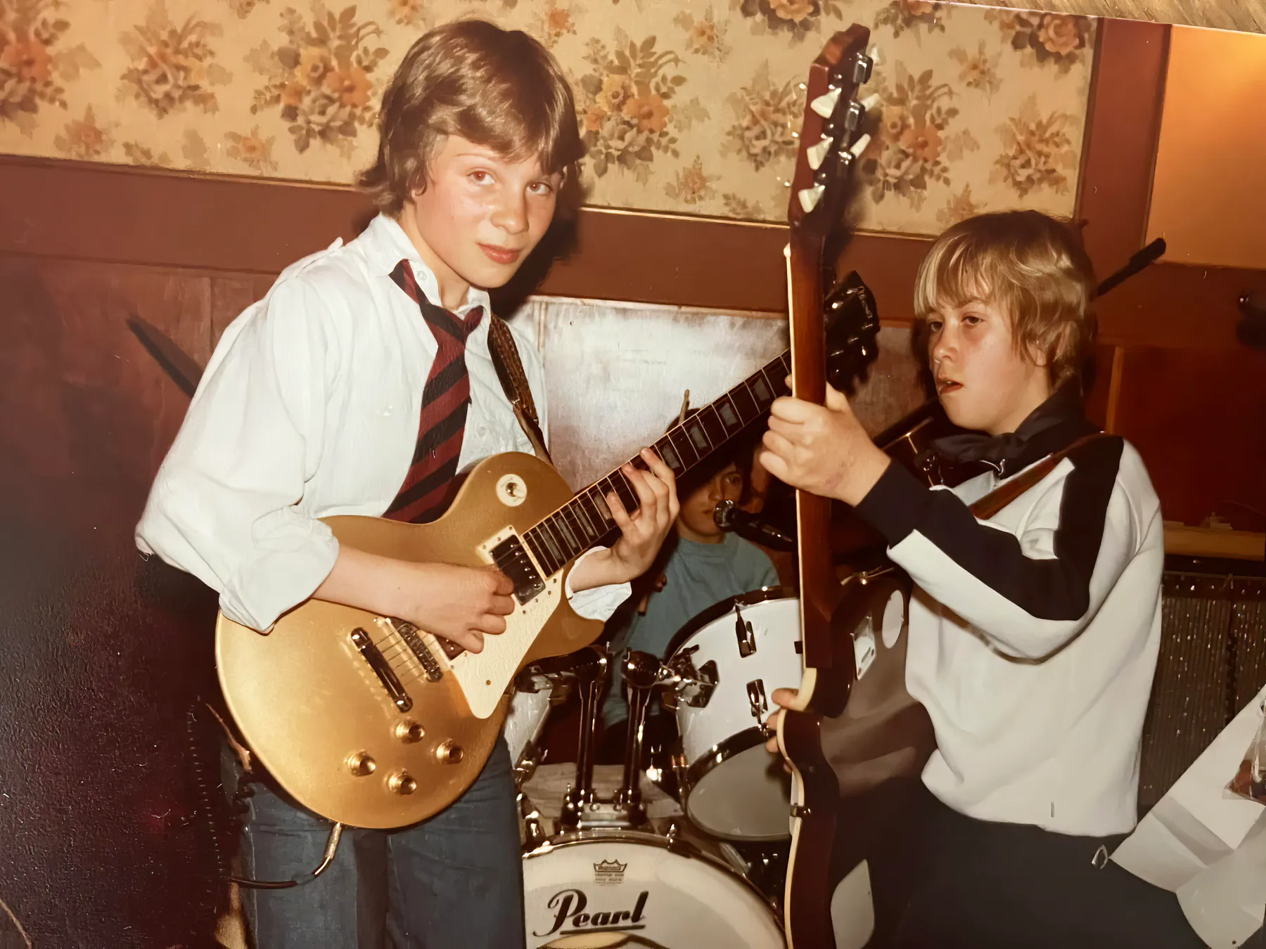 Unge musikere med guitarer og trommer i øvelokalet
